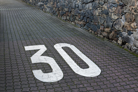 Speed limit 30 painted on interlocking paver stonesの写真素材