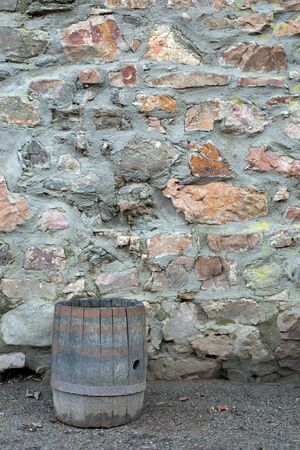 Wooden brown barrel on a stone wallの写真素材