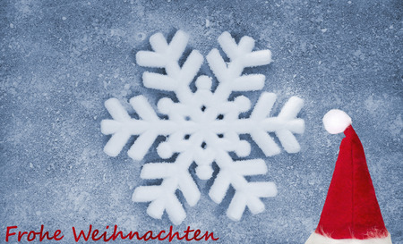 Christmas hat, snowflake, grey fiber fabric, blue glitter film and the words Frohe Weihnachten (german words for Merry Christmas)の写真素材