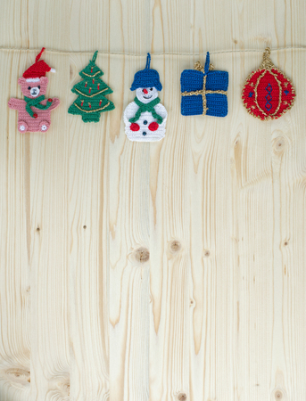 Several crocheted christmas hangers on a cord on wood, backgroundの写真素材