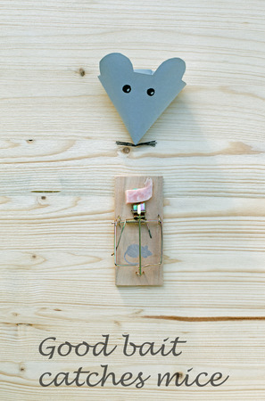 Mouse made of paper and mousetrap with bacon on wood. Good bait catches miceの写真素材