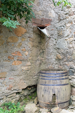 Wooden brown barrel on a stone wallの写真素材