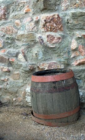 Wooden brown barrel on a stone wallの写真素材