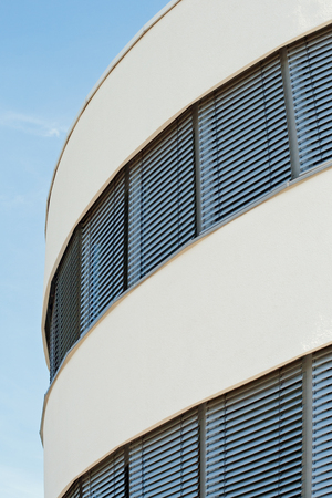 Office building with closed blinds, blue skyのeditorial素材