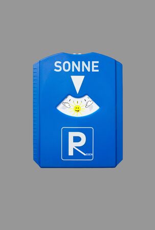A german parking disc with the german words for sun and rain isolated on greyの写真素材