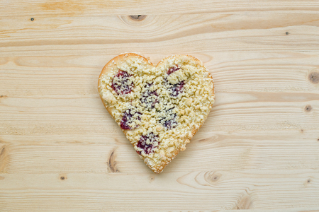 Streusel or crumble heart with jam on woodの写真素材