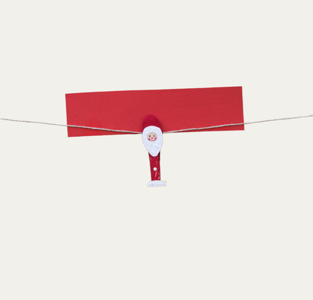 One christmas man with clothes peg on a cord, isolated on whiteの写真素材