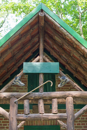 A wooden cabin with walking boots and walking stick in a forestの写真素材