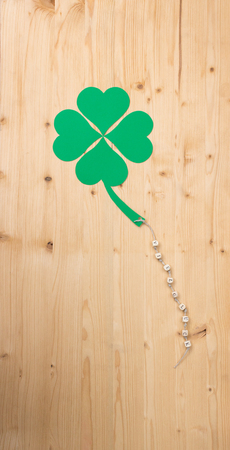 The german words for Good Luck and a cloverleaf on a cord on woodの写真素材