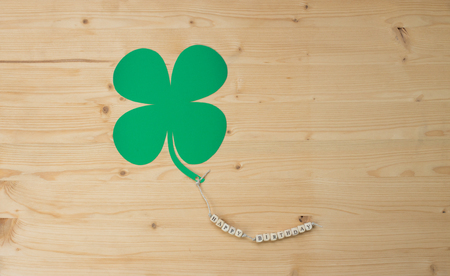 The words Happy Birthday and a cloverleaf on a cord on woodの写真素材