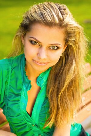 Closeup portrait of a beautiful young girl relaxing in a park

の写真素材