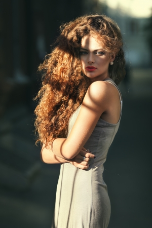 Summer portrait of a beautiful young Caucasian girl with curly hairの写真素材
