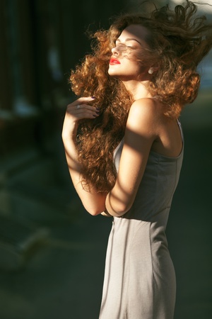 Summer portrait of a beautiful young Caucasian girl with curly hairの写真素材