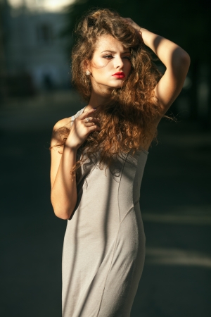 Summer portrait of a beautiful young Caucasian girl with curly hairの写真素材