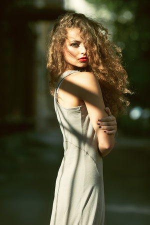 Summer portrait of a beautiful young Caucasian girl with curly hairの写真素材