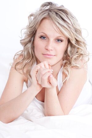 Beautiful sexy young blonde woman on the bedの写真素材