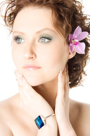 Closeup studio portrait of a beautiful young woman with pink flower, isolated on white backgroundの写真素材