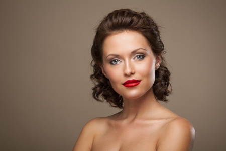 Face of a beautiful young brunette woman with bright makeup and curly hairの写真素材