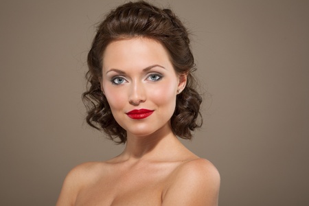 Face of a beautiful young brunette woman with bright makeup and curly hairの写真素材