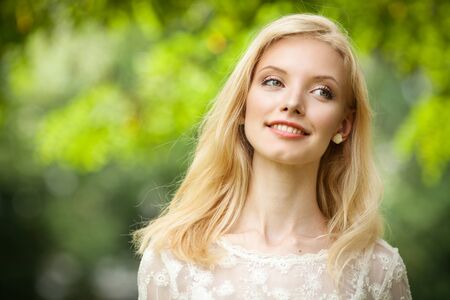 Beautiful young blond woman on abstract green backgroundの写真素材