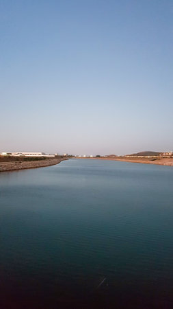 Enchanting beauty of a serene evening by the river as the setting sun casts its golden rays upon the...