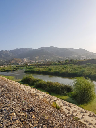 Majestic valley and mountains in the Rif mountains of Morocco. The valley is lush and green, with rolling hills and a river running through it. The mountains are towering and craggyの写真素材