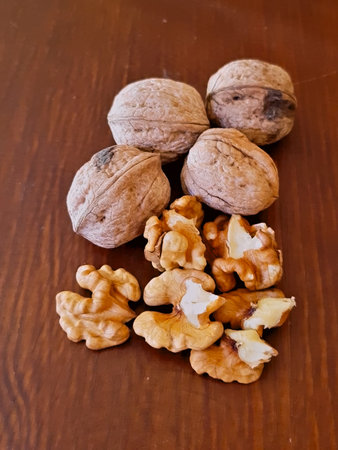 Close-Up of Peeled and Unpeeled Walnuts, The peeled walnuts reveal their intricate, brain-like...