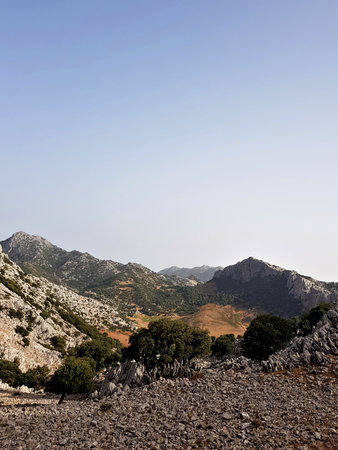 A dramatic panorama of rolling hills near Jbel Kelti; layered ridgelines, changing light that reveal...