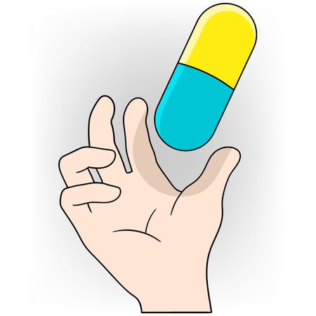 A hand holding a pill with a blue and yellow color, flat illustration vectorのイラスト素材