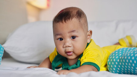 A fat and healthy five month old baby is learning to roll over to support his head.