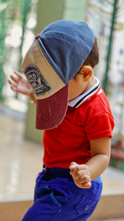 Toddler nosy behavior covers his face with a hat and walks blindfold