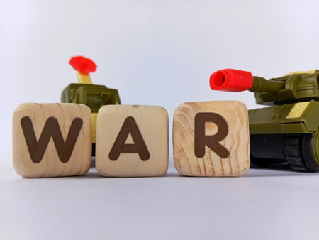War text on wooden cubes with toy military tank on white background.