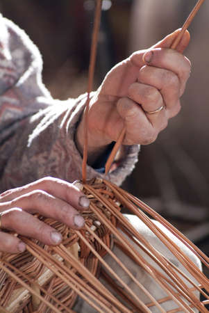Carpenter weaves the rush to make a basketの写真素材