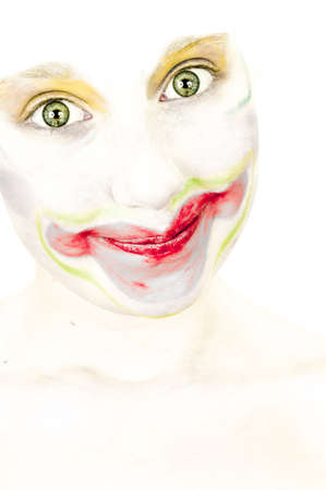 artistic portrait of a little girl with face painted as a clown, mischievous smilesの写真素材