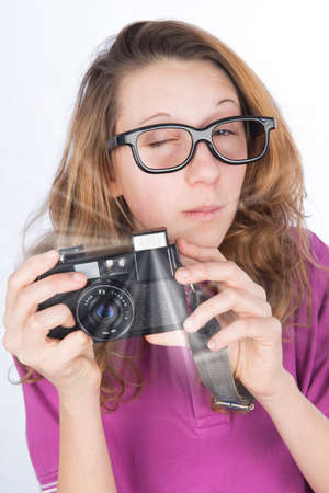 Young nerd photographer with camera in hand which make a flashの写真素材