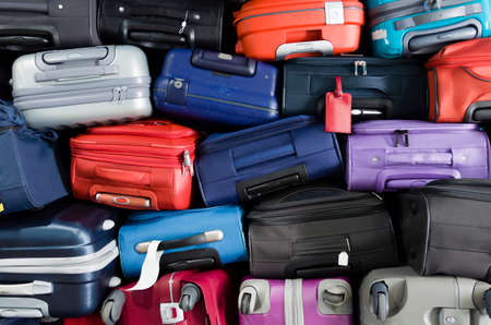 Suitcases multicolor stacked for transport one above the otherの写真素材
