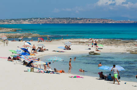Formentera, Spain, CalÃ³ de Sant August - July 23, 2015: View on the beach, many people with their umbrellas, against the backdrop visible part of the islandのeditorial素材