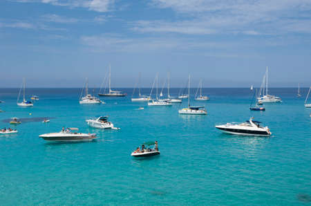 Formentera, Spain, Plaja de Cala Saona - July 21, 2015: People on boats moored in a cove on a...