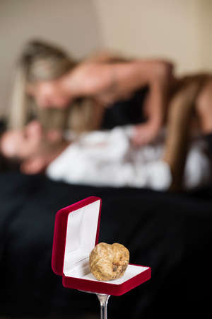 White truffle of Piedmont Italy, in red box for jewelry on the background undressed couple in loving effusionsの写真素材