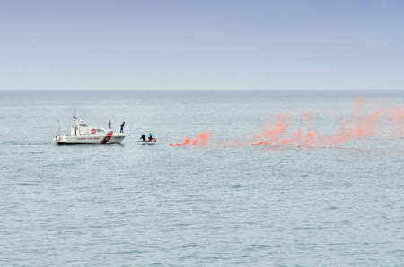 Liguria, Italy, June 5, 2016: Coast Guard ship, save to a small boat that triggered a red signal smokeのeditorial素材