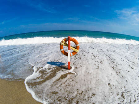 The waves reach the lifebelt in the deserted beach, even the sea is desertedの写真素材
