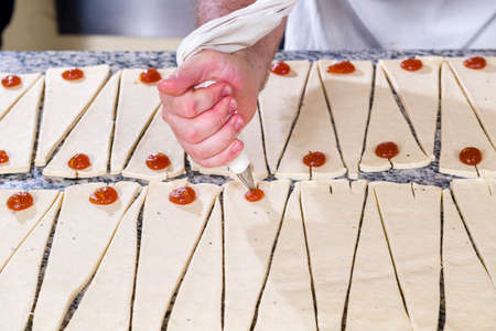 Stages of preparation, pastry chef prepares jam croissant in pastry shopの写真素材