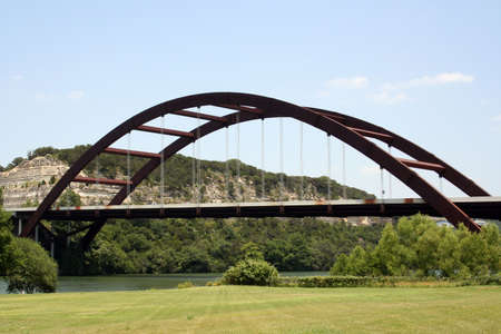 A shot of the Austin 360 Bridge on a clear calm day.  There was some traffic, but it was not too bad on the bridge.  In the distance is the golf course.  You can also see the radio towers in the background.  This is a very pretty picture of the bridge andの写真素材