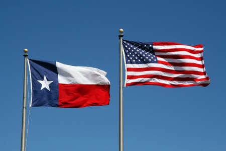 A Texas and US flag boldly flapping in the wind.の写真素材