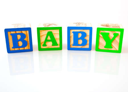 The letters B, A, B, Y spelling baby with wooden blocksの写真素材