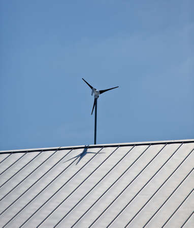 a small wind turbine windmill attached to a roofの写真素材