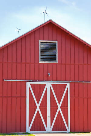 A red barn with solar and wind power generating electricityの写真素材