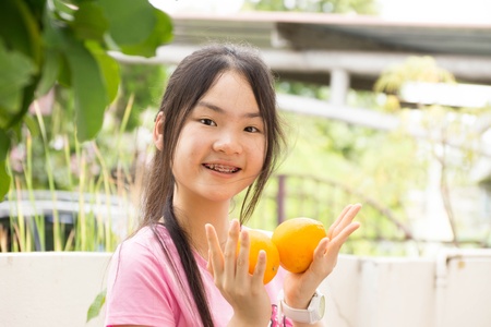 Young lovely woman is holding two orangesの写真素材