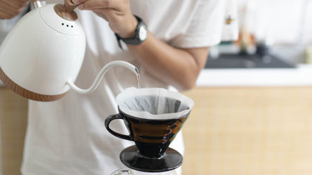 Barista is making drip brewing, filtered coffee, or pour over coffee with hot water and filter paper...