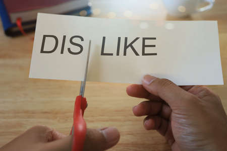 Man holding scissors and cutting paper from dislike to like. Mindset concept.の写真素材